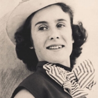 Monochromatic picture of a young woman with a hat and striped bowtie.
