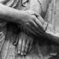Black and white close up of Greek funerary stele in the gesture of dexiosis marble carving