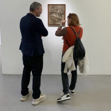 Christian Alandete and Pavlina Vagioni talking in front of a painting by Eugène Carrière at Kamel Mennour gallery Paris.