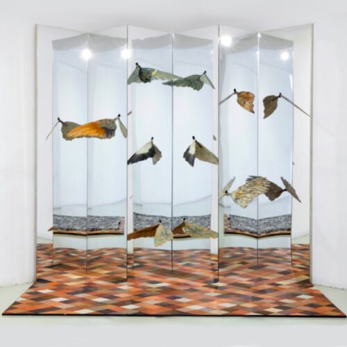 A six-fold screen of mirrors and six bird wings reflected on its surfaces
