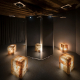 Dim room with four glowing salt lamps around a central black mirrored partition in a circle of light.